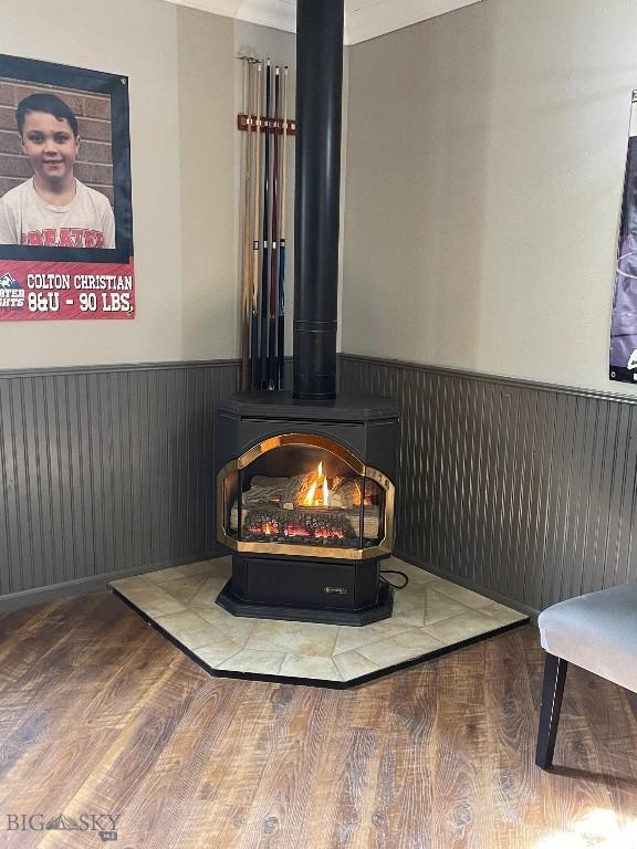 details featuring a wood stove and hardwood / wood-style floors