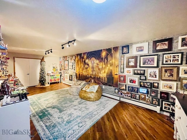 recreation room featuring track lighting and dark hardwood / wood-style flooring