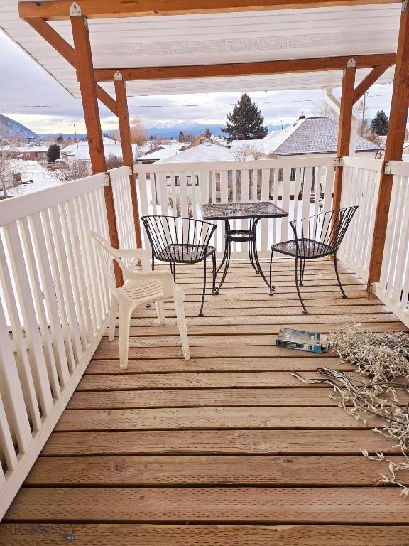 snow covered deck with a mountain view