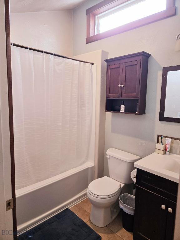 full bathroom with shower / bath combination with curtain, toilet, vanity, and tile patterned flooring