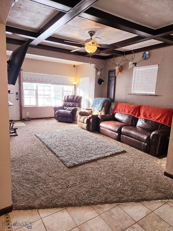 tiled living room featuring coffered ceiling, beam ceiling, and ceiling fan