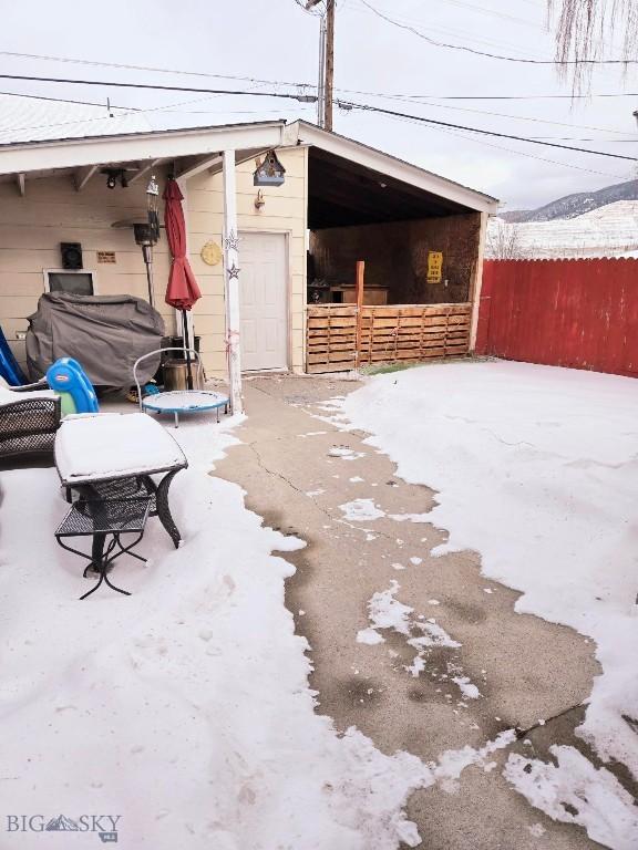 snow covered patio featuring an outdoor structure