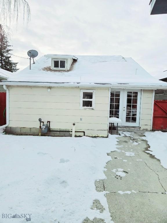 snow covered property with french doors