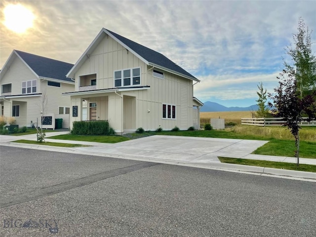 modern farmhouse style home with a mountain view, board and batten siding, and a front lawn