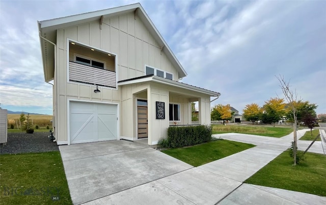 view of front of home with driveway, a balcony, board and batten siding, and a front lawn