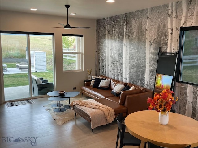 living area featuring light hardwood / wood-style flooring and ceiling fan