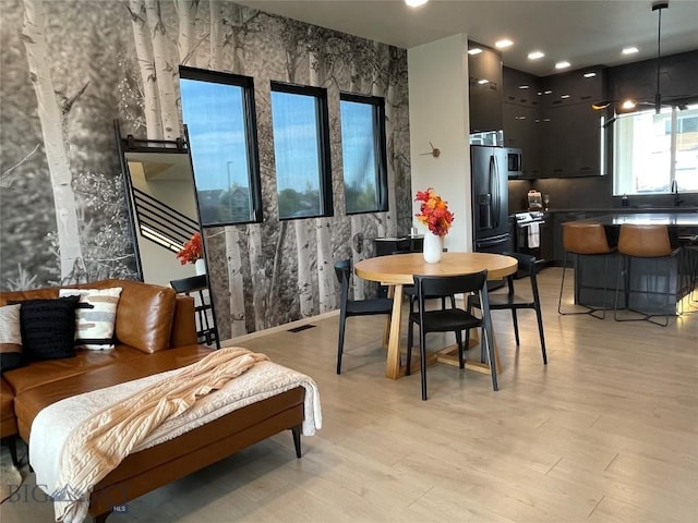 dining space featuring visible vents and light wood-style flooring