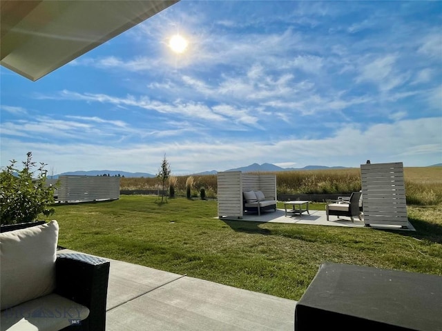 view of yard featuring a mountain view, a patio, and outdoor lounge area