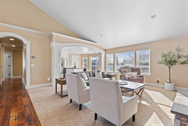 interior space with sink, hardwood / wood-style floors, decorative columns, and vaulted ceiling