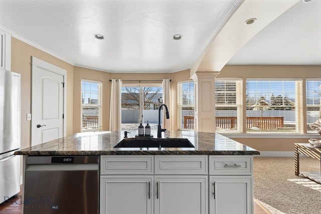 kitchen featuring sink, a center island, stainless steel appliances, and dark stone countertops