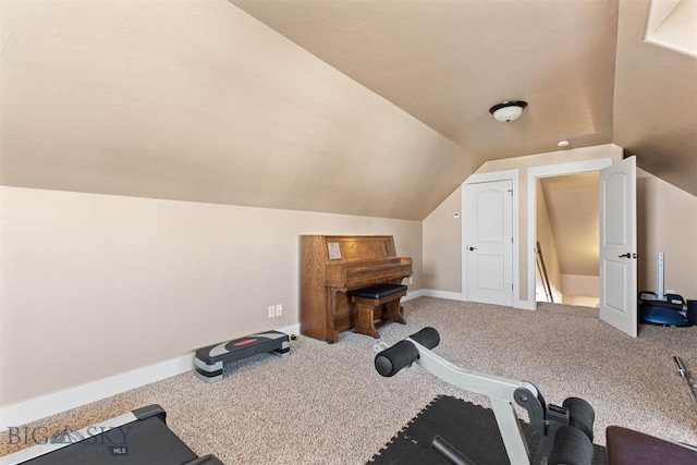 exercise room featuring lofted ceiling and carpet flooring