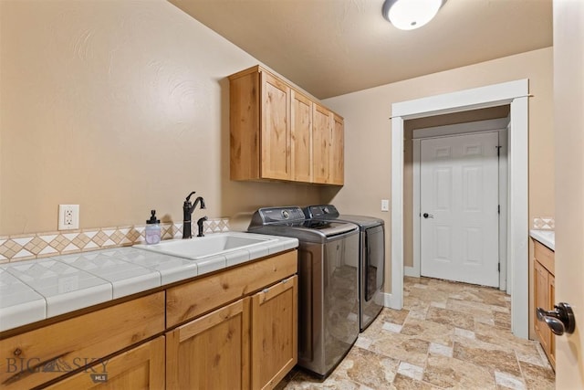 laundry area with sink, cabinets, and washing machine and clothes dryer