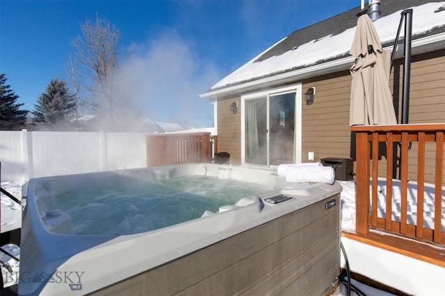 snow covered deck with a hot tub