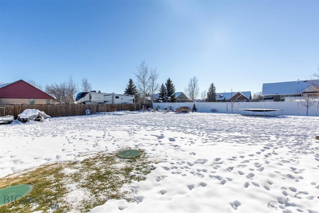 yard covered in snow with a trampoline