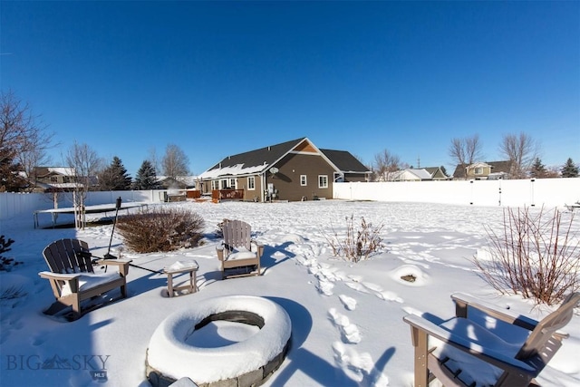 yard covered in snow featuring a trampoline