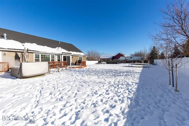 yard layered in snow with a deck