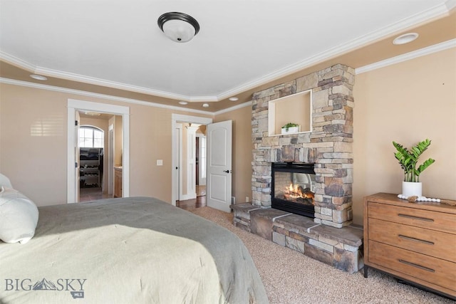 carpeted bedroom with crown molding and a stone fireplace