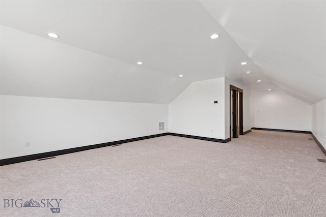 bonus room with light colored carpet and lofted ceiling