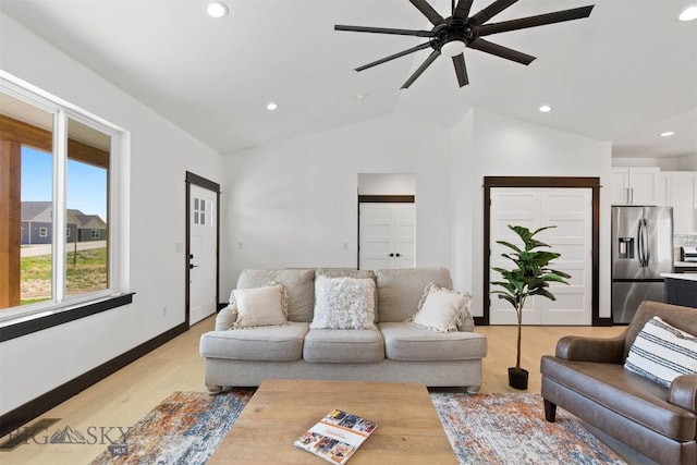 living room with ceiling fan, lofted ceiling, and light wood-type flooring