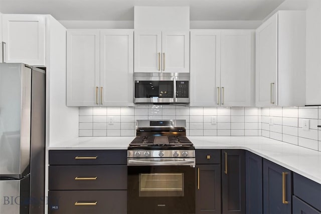 kitchen featuring backsplash, white cabinets, blue cabinets, light stone counters, and stainless steel appliances