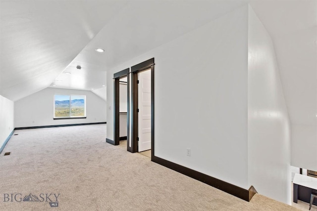 bonus room featuring light carpet and vaulted ceiling