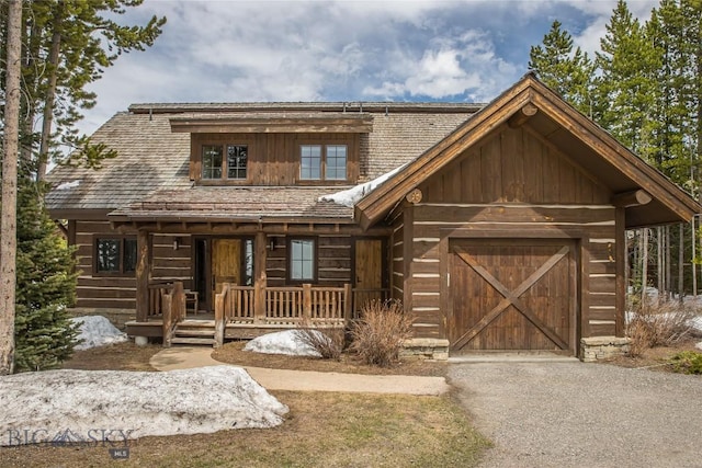 cabin with a porch and a garage