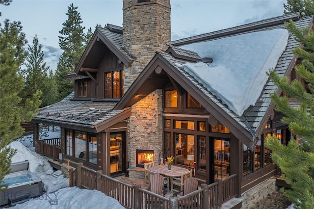 rear view of house featuring an outdoor stone fireplace