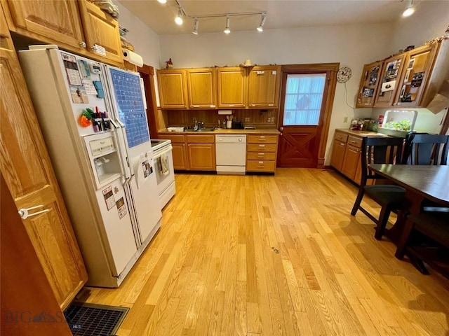 kitchen featuring sink, white appliances, and light wood-type flooring