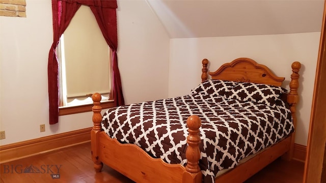 bedroom with hardwood / wood-style floors and vaulted ceiling