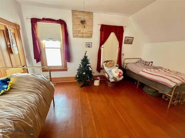 bedroom featuring hardwood / wood-style floors and vaulted ceiling