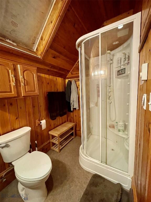 bathroom with wooden walls, a shower with shower door, lofted ceiling, and wood ceiling