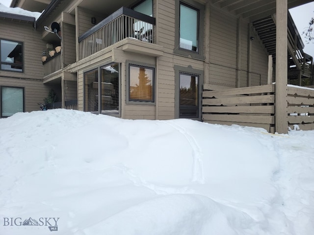 snow covered property featuring a balcony