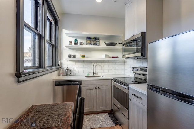 kitchen featuring stainless steel appliances, tasteful backsplash, sink, and light hardwood / wood-style floors