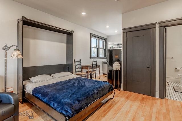 bedroom with hardwood / wood-style flooring and ensuite bathroom