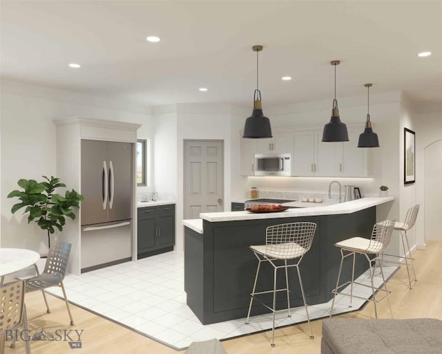 kitchen featuring appliances with stainless steel finishes, white cabinetry, hanging light fixtures, a kitchen breakfast bar, and kitchen peninsula