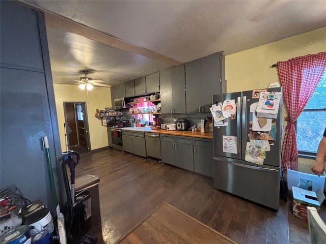 kitchen with dark wood-type flooring, gray cabinets, and appliances with stainless steel finishes