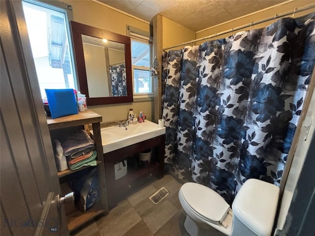 bathroom with vanity, toilet, curtained shower, and a wealth of natural light