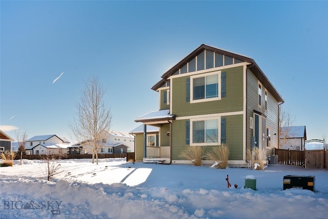 snow covered house featuring central AC