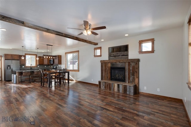 living room with beamed ceiling, dark wood-type flooring, and ceiling fan