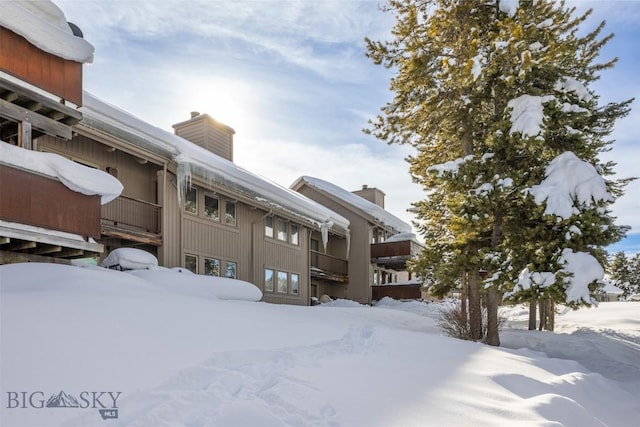 snow covered property featuring a balcony