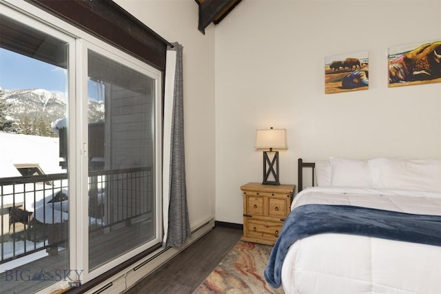 bedroom with dark wood-type flooring, baseboard heating, access to exterior, a mountain view, and beamed ceiling