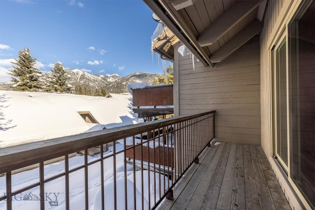 snow covered back of property featuring a mountain view