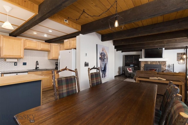 kitchen featuring pendant lighting, sink, wooden counters, decorative backsplash, and beam ceiling