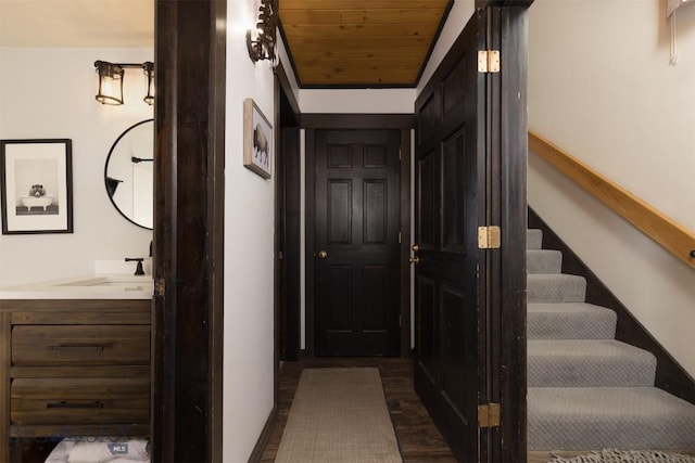 hallway featuring dark hardwood / wood-style flooring, sink, and wood ceiling