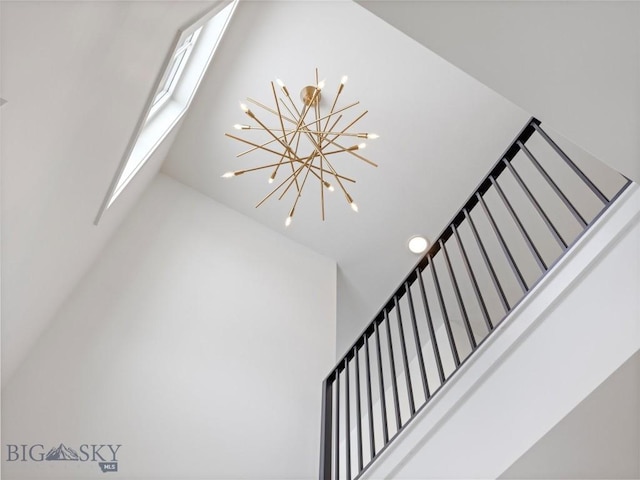 staircase with an inviting chandelier