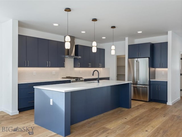 kitchen featuring blue cabinetry, appliances with stainless steel finishes, sink, and an island with sink