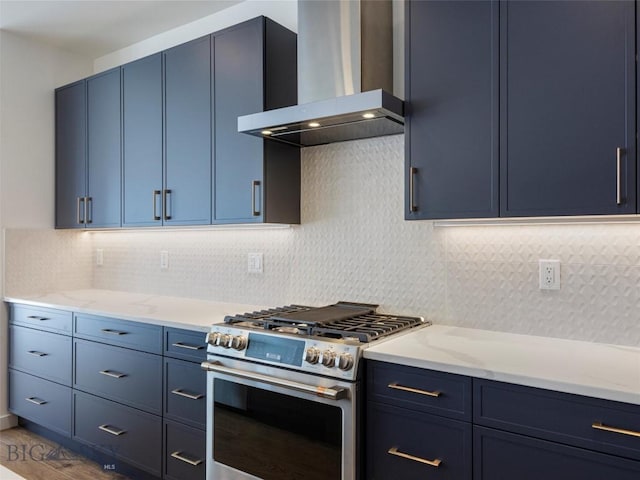 kitchen with dark wood-type flooring, stainless steel range with gas cooktop, wall chimney exhaust hood, and blue cabinets