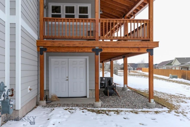 snow covered property entrance featuring cooling unit and a garage