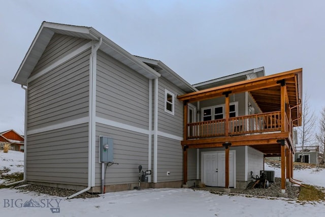 snow covered rear of property with central AC