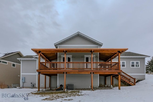 snow covered property featuring central AC and a deck